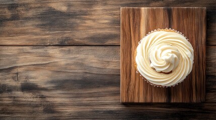 Wall Mural - A beautifully frosted cupcake on a wooden board, inviting for a sweet treat.