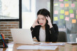 © Witoon - Image of Asian businesswoman working with laptop in home office. Beautiful woman sitting at desk, laptop, smartphone and documents on table.