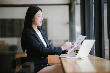 Beautiful Asian businesswoman working on laptop in office