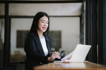 Beautiful Asian businesswoman working on laptop in office