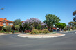 © Doublelee - Charming suburban aesthetic of a roundabout in a sunny Australian neighborhood surrounded by colorful flowers and plants, creating a vibrant and inviting atmosphere in the suburb.