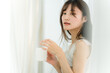 © buritora - 朝、家で白湯・コーヒー・ホットドリンク・カフェオレ・カフェラテを飲む笑顔のアジア人女性