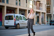 © Cavan Images - Businesswoman walking and talking on the phone in a vibrant city