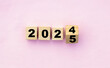 © Photix Studio - Year changing from 2024 to 2025 with wooden blocks symbolizing target business for the upcoming year. This represents planning, investment, and innovation as ideas move from the end of 2024 new year