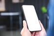 © Farknot Architect - Mockup image of a woman holding and using mobile phone with blank desktop in cafe