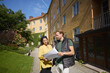 © Johnér - Male architect examining blueprint with female colleague while standing near residential building at sunny day