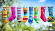 © Kunut - Brightly colored fun socks hanging on clothesline, showcasing variety of patterns and designs against vibrant outdoor backdrop. cheerful display evokes sense of joy and playfulness
