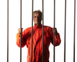 © serikbaib - Portrait of a male prisoner behind bars on a white background