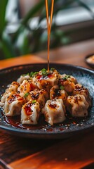 Glistening dumplings, perfectly shaped and adorned with a vibrant orange sauce, resting on an elegant black plate that reflects the light of its surroundings