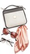 © bcendet - A small, beige purse, sunglasses and a silk scarf are arranged on a white background.