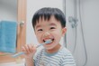 © Anzhela - Joyful asian child brushing teeth in a clean bathroom  emphasizing dental hygiene and bright smiles