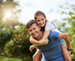 © Nikish Hiraman/peopleimages.com - Dad, kid and piggy back in garden portrait with bonding, smile and hug on outdoor adventure with weekend games. Happy face, father and daughter in backyard together with support, trust and summer fun