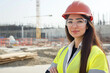 © romanets_v - Confident female construction engineer in safety gear at building site
