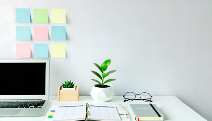 A modern workspace setup featuring a laptop planner and green plants for enhanced productivity and inspiration