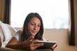 © peopleimages.com - Relax, sofa and child with tablet in home for online learning, watching movies and internet videos. Family, living room and young girl on digital tech for games, streaming cartoons and website