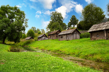 Medieval complex of traditional wooden baths reflected in the water on the bank of the river in the village of Vyatskoye in Yaroslavl region in Russia in the summer