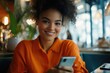 © Vii - A woman sits at a table looking at her cell phone
