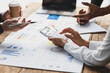 © Wasan - Businessman meeting with financial advisors discussing budget analysis, financial statistics figures and finance planning on wooden tables in the office.