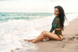 © peopleimages.com - Happy woman, fashion and thinking on beach for beauty, confidence and luxury brand bikini. Girl, sexy style or makeup at California ocean for aesthetic, travel or freedom in water for summer vacation