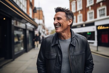 Portrait of a handsome middle-aged man laughing in the city