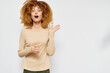 © SHOTPRIME STUDIO - Surprised woman with curly hair showcasing excitement against a plain light background Her expression is joyful, enhancing engagement and positivity in the composition