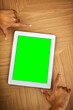 © peopleimages.com - Person, hands and tablet with green screen for advertising, marketing or software app above on wooden table. Top view, developer and closeup with technology display, chromakey or UI for UX or mockup