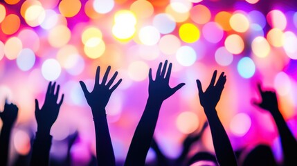 Silhouette of raised hands at a concert with bright stage lights in the background. Music festival and live performance concept.