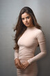 © N Hiraman/peopleimages.com - Fashion, portrait and wind with woman in studio on gray background to model stylish wardrobe. Classic, satisfaction and simple with confident or serious person in clothes outfit for elegance