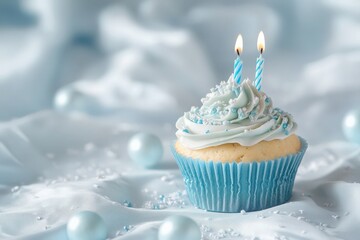 A frosted cupcake with two lit candles on a blue background.