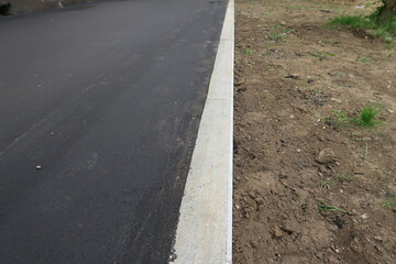 laying of sidewalks with new asphalt. New asphalt with marble curbs and earth.