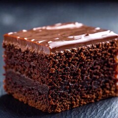 Wall Mural - A close-up shot of a chocolate cake slice with rich, glossy frosting in sharp focus, while the background is softly blurred, emphasizing the texture and indulgence of the cake