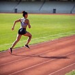© LIGHTFIELD STUDIOS - A soft focus shot of a multiracial female runner sprinting on a track, with a slight blur to her figure and the surrounding stadium, adding a sense of speed and motion