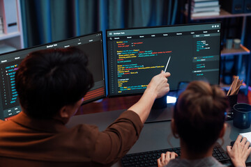 Smart IT developer looking at coding program application on computer screen of online website at back side, analyzing intelligent database system development on business marketing at office. Infobahn.