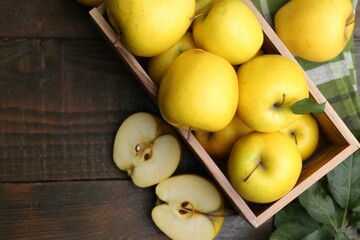 Canvas Print - Ripe yellow apples in crate on wooden table, top view. Space for text