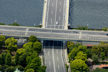 Aerial view of two intersecting highways with a bridge over the river in Tokyo, Japan creates a crossroads of streets