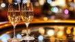 © NatthaphonSiri - Two Glasses of Champagne with a Warm, Bokeh Background.