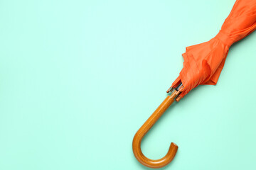 Orange stylish umbrella on green background