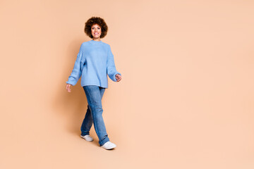 Full size photo of optimistic pleasant girl dressed knit sweater jeans go shopping to empty space isolated on pastel color background