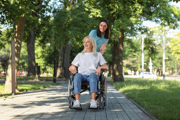 Canvas Print - Senior woman in wheelchair and her daughter spending time together outdoors