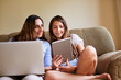 © peopleimages.com - Tablet, laptop and mom with child on sofa for online learning, watching movies and internet videos. Family home, living room and mother with girl on digital tech for games, remote working and website