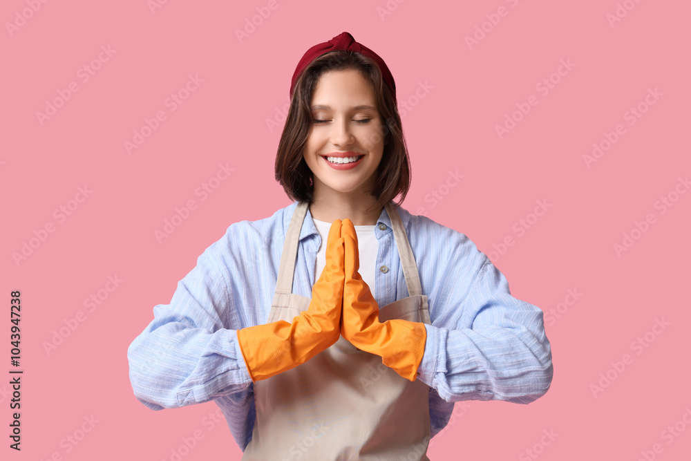 Pretty young housewife meditating on pink background