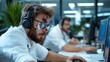 © Pinklife - A bearded man with facial injuries and headphones focuses intently on his computer screen in a modern office, ignoring his wound in pursuit of work goals.