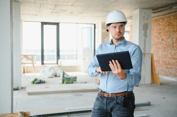 Engineer with tablet, building inspection. Construction man in helmet build new house