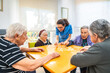 © unai - Nurse and senior people playing board skill games