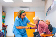 © unai - Nurse helping to stand up to senior woman at geriatrics
