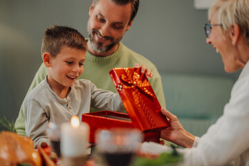 Happy family celebrating christmas opening present together