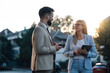 © Zamrznuti tonovi - Two business people having conversation on street using digital tablet and smartphone