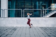 © Zamrznuti tonovi - Young woman running outdoors in urban setting