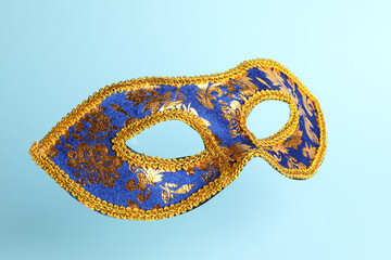 Beautiful bright carnival mask on light blue background