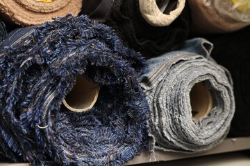 Many different types of fabric on shelves in professional workshop, closeup